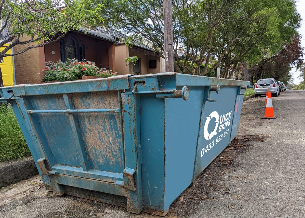 Six cubic metre skip bin hire with rear door blue skip bin Fairfield area and Smithfield placed on street in front of property
