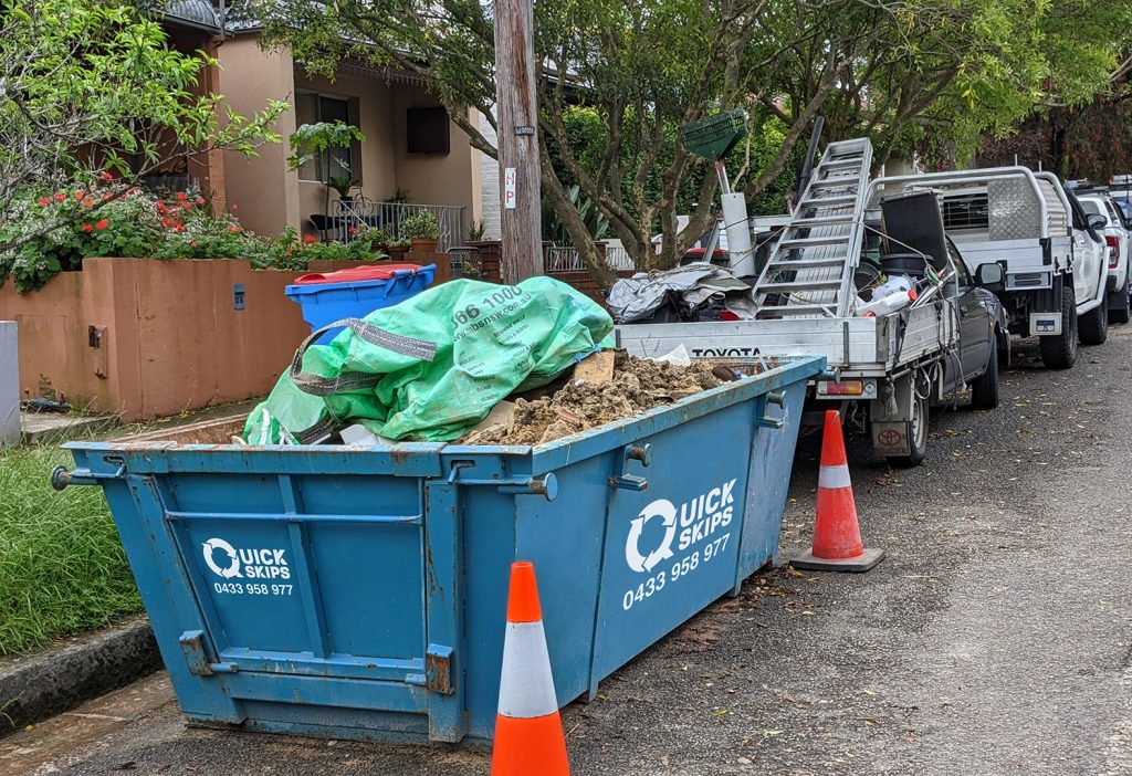 Medium sized 6 cubic metre skip bin hire with rear door blue skip bin Fairfield area and Smithfield placed on street in front of property