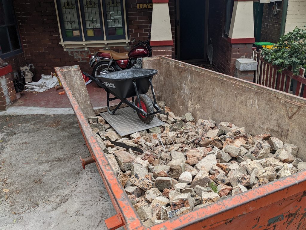 4 cubic metre skip bin with wheelbarrow in the Penrith area